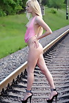 Leggy blonde Margo H strips to ankle strap heels on railway tracks