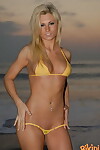 Slender blonde Jessi shows her tight ass in a string bikini on the beach