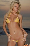 Slender blonde Jessi shows her tight ass in a string bikini on the beach