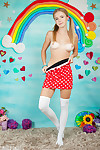 Charming young girl shows her tan lined body in long socks and pigtails